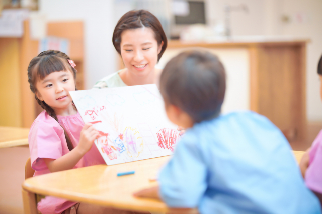 絵本で遊ぶスタッフと子供